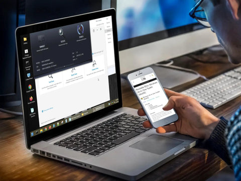 Person holding smartphone next to a laptop displaying Bootable USB Repair Kit For Windows PCs With Antivirus Data Recovery And Password Reset