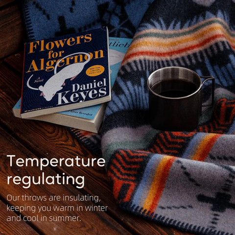 100 Percent Virgin Wool Blanket 62 By 86 Inches Warm Thick And Washable draped over wooden surface with books and mug