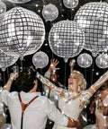 Group dancing under Metallic Silver Disco Balloons In Mixed Sizes 32-Inch, 22-Inch, And 10-Inch - 20 Count 4D Mylar Balloons at a party.