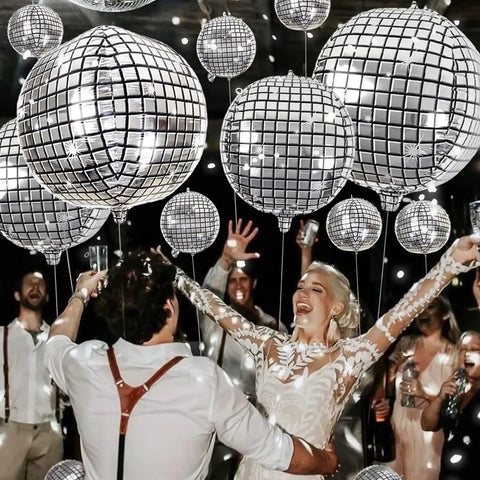 Group dancing under Metallic Silver Disco Balloons In Mixed Sizes 32-Inch, 22-Inch, And 10-Inch - 20 Count 4D Mylar Balloons at a party.