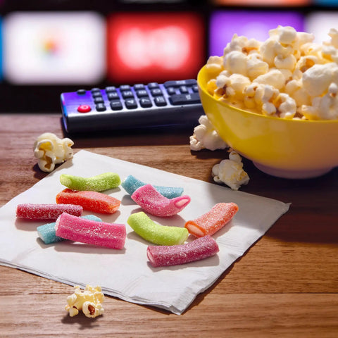 Mixed Fruit Rope Bites Candy on napkin with popcorn bowl and TV remote in background