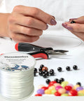 Person using Flat 0.8 mm Elastic Bead Rope for Jewelry Making, clear polyester spandex string, durable for bracelets, 100 m roll