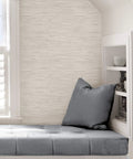 Cream Vinyl Grassweave Peel And Stick Wallpaper for Easy DIY Accent Walls shown in cozy reading nook.