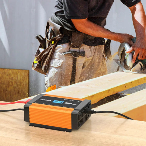 Gutsy 2000W Power Inverter Switches 12V Battery To 120V AC, displayed in use on a workbench with a power saw in action.