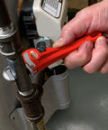 Heavy Duty 6 Inch Straight Pipe Wrench For Plumbing Projects With Serrated Steel Jaw And Cast Iron Handle Red Finish in use
