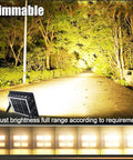 Super Bright Rechargeable Solar Work Light Packed With Huge Battery For All Your Camping Emergencies Storm Prep And Power Outages Portable Waterproof Lantern With Handy Hook And Stand Dimmable Settings Make It A Must Have showcasing adjustable brightness in a wooded area.