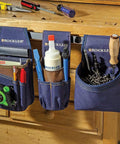 Heavy Duty Carpenter Tool Pouch With Belt Clip For Easy Access To Tape Measure Pencils Square And More Clip On Utility Bag For Woodworking Pros And DIYers, showing hanging on wooden bench with multiple tools
