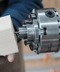 Top Tier Crown Drive Center With Spring Loaded Point fits most four jaw chucks, shown with wood piece being held securely.
