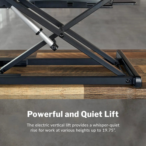 Vari Pro Plus 36 Electric Standing Desk Converter In Stylish Walnut Finish showing electric lift mechanism on wooden surface.