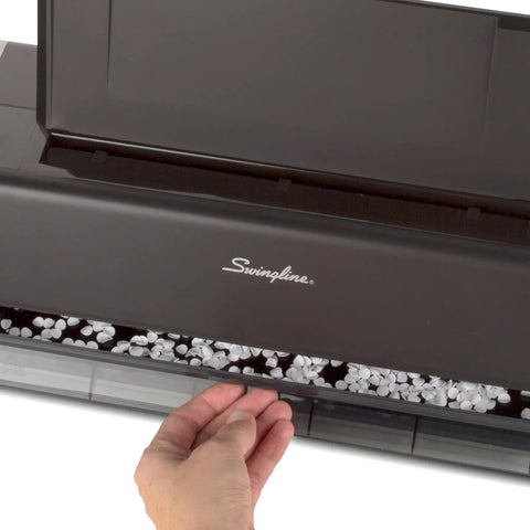Hand accessing tray of electric three hole punch for 28 sheet capacity with auto jam reverse and touch screen control platinum finish