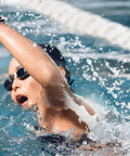 Charge 3 SE Fitness Tracker With Graphite White Silicone Band worn by swimmer in pool, demonstrating water resistance.