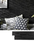 3D Reclaimed Barn Wood Wall Panels Set Of 10 For Easy DIY Glue And Nail Install Premium Dark Graphite Finish 9.5 Sq Ft Coverage No Power Tools Needed Rustic Deep Textured Look with decorative pillows against the wall.