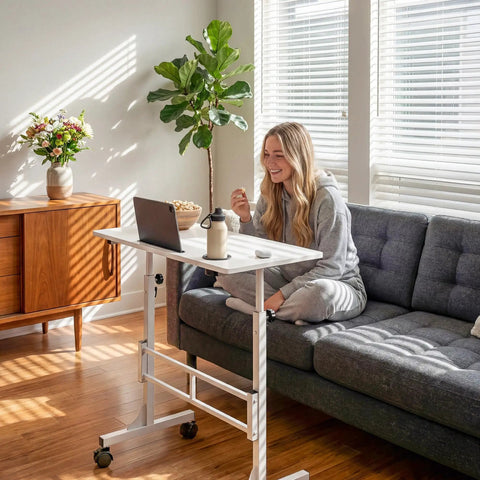 Person using Adjustable Standing Desk On Wheels For Treadmills And Home Offices Portable Laptop Workstation, white, in living room.