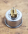 Close-up of motorcycle oil pressure gauge with chrome housing and brass 1/8 NPT fitting