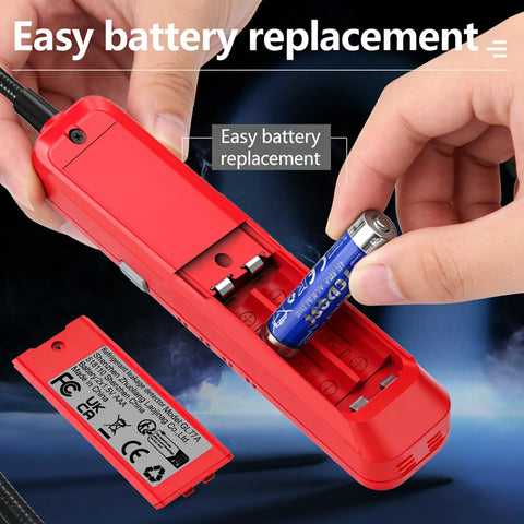 Red handheld freon leak detector, angled view with open battery slot as AA battery is inserted