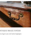Antique Brass Drop Bail Drawer Pull on wooden dresser with bead center detail in warm aged finish