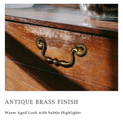 Antique Brass Drop Bail Drawer Pull on wooden dresser with bead center detail in warm aged finish