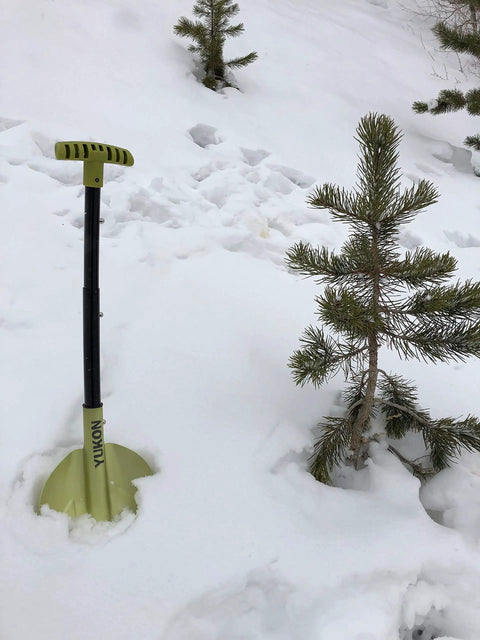 Grab And Go Collapsible Snow Shovel For Camping And Car Emergency Kit in snow beside small tree