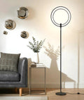 Torchiere-Style No-Fuss Dimmable LED Floor Lamp For Living Rooms And Offices next to sofa with wall decor and small table.