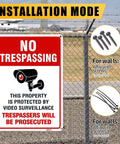Straight Up Legal Deterrent Video Surveillance And No Trespassing Signs 4 Pack Aluminum Security Plates on a fence outdoors.