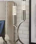 Two Cylinder Water Drop Dancing Night Lights in satin nickel on table against brick wall.