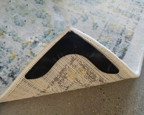 Close-up of corner with Non Slip Rug Grippers For Every Floor, V Shaped Corner Anti Curling Pads on a patterned rug.