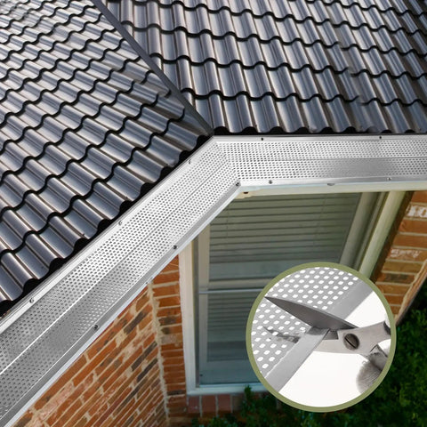 Built Tough 5 Inch Aluminum Gutter Guards 20 Pack 80 Ft Total installed on a roof edge, showing cutting with scissors for size.