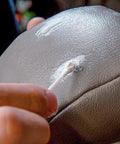 Applying Leather Repair Filler For Holes Tears And Scratches In Leather Car Seats Furniture And Shoes DIY Friendly Flexible And Paintable For Seamless Repairs Made In USA 2 Fl Oz on brown leather surface