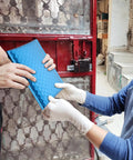 Two people exchanging Blue Aluminum Film Bubble Mailers 50 Count, Built Tough Padded Envelopes With Self Sealing outdoors.