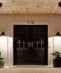 Allenbury 12 Inch One Light Outdoor Wall Light With Textured Black Finish lighting up double door entrance at night