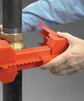 Hands securing Red Ball Valve Lockout For One Half To Two And A Half Inch Pipe, Polypropylene Body, industrial safety device