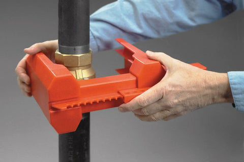 Hands securing Red Ball Valve Lockout For One Half To Two And A Half Inch Pipe, Polypropylene Body, industrial safety device