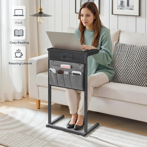 Woman uses C Shaped End Table With Built In Charging Station For Small Spaces 28 Inch Tall Couch Side Table with 2 Tier Storage Pouch