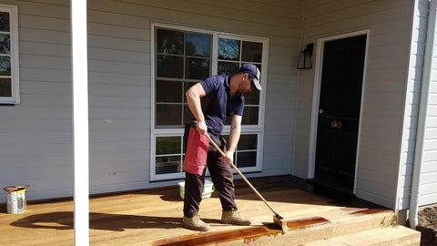 Man using Deck Boss 7 Inch Deck Stain Brush Applicator For Wood Concrete And Composite Coatings Water Based And Oil Based Stains Seals