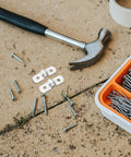 Heavy Duty Stainless Steel Cable Conduit Clamps on a work surface with screws and a hammer.
