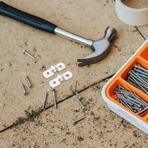 Hella Tough 100 Pack Stainless Steel U Shaped Pipe Clamps on ground with screws and hammer for easy installation.