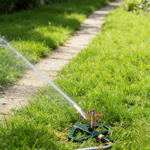 Impact Pulsating Lawn Sprinkler With Metal Base in action, showing water spray on grass, adjustable 360 degree rotation, zinc alloy build
