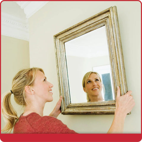Woman using Picture Perfect Hanging System For Wall Art Up To Fifty Pounds No Wire Mount Kit to hang framed mirror flush on wall