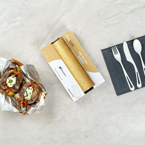 Gold Embossed Pop-Up Foil Sheets 10.8 X 9 Inch with baked potatoes in foil and dining utensils