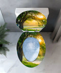 Resin Toilet Seat for Home Bathroom featuring a nature design with trees and sunlight, elongated shape, top view.