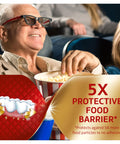 Senior man in cinema enjoying popcorn with text overlay about Power Max Hold Denture Adhesive Cream for Super Strong Hold and Food Seal.