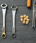 8pc Brass Furniture Legs For Wooden Trays And Boxes, cone shaped metal feet on dark wood surface with tools