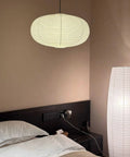 Large White Chinese Paper Ceiling Lamp Shade And Oval Pendant Light Cover With Vintage Round Chandelier Lantern Design For Easy Peasy Setup And Total Room Upgrades That Bring Killer Decor Vibes hanging above a bed.
