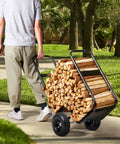 Person hauling Heavy Duty Log Cart Built Tough For Firewood Up To 250 Lbs With Pneumatic Wheels And Elevated Guardrails outdoors