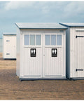 Beachside restroom cabin with male and female signs on white doors with modern design.