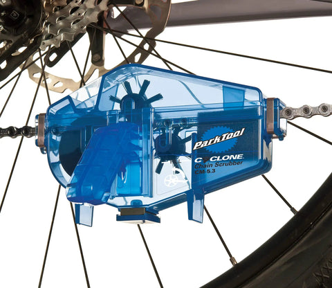 Cyclone Chain Scrubber CM-5.3 in blue attached to bike chain, showing easy grip handle and mess-free solvent wicking sponge.