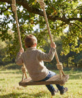 Child on a swing using Heavy Duty Workhorse Three Quarter Inch 100 Ft Natural Jute Rope For Nautical Decor Porch Swing Railing And Home Projects Braided Four Strand Hemp Style Cord Flexible Easy To Tie Knots 880 Lbs Safe Working Load Durable Natural Fiber outdoors