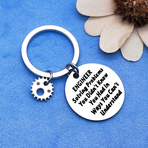 Engineer Solving Problems You Didnt Know You Had Keychain with gear charm on blue background.