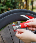 Using Grab-And-Go 8-In-1 Bike Repair Kit With CO2 Inflator on a bike tire for quick inflation on the road.
