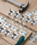 50 Pack Of 1/2 Inch Drywall Corner Repair Clips Featuring Top Shelf Wall Backup Fasteners For Studs laid out on a wooden surface with tools.